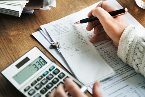 Foto: Person arbeitet am Taschenrechner